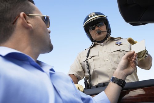 This is an image of a man getting a traffic ticket from a police officer before calling a Springdale traffic violation lawyer