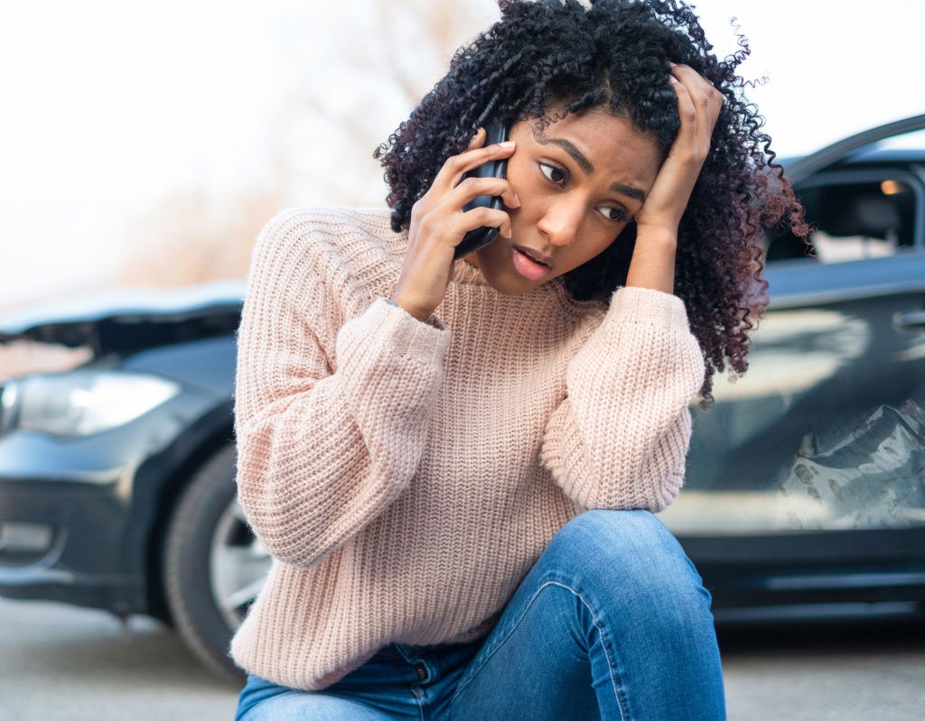 Woman making a phone call after a car accident