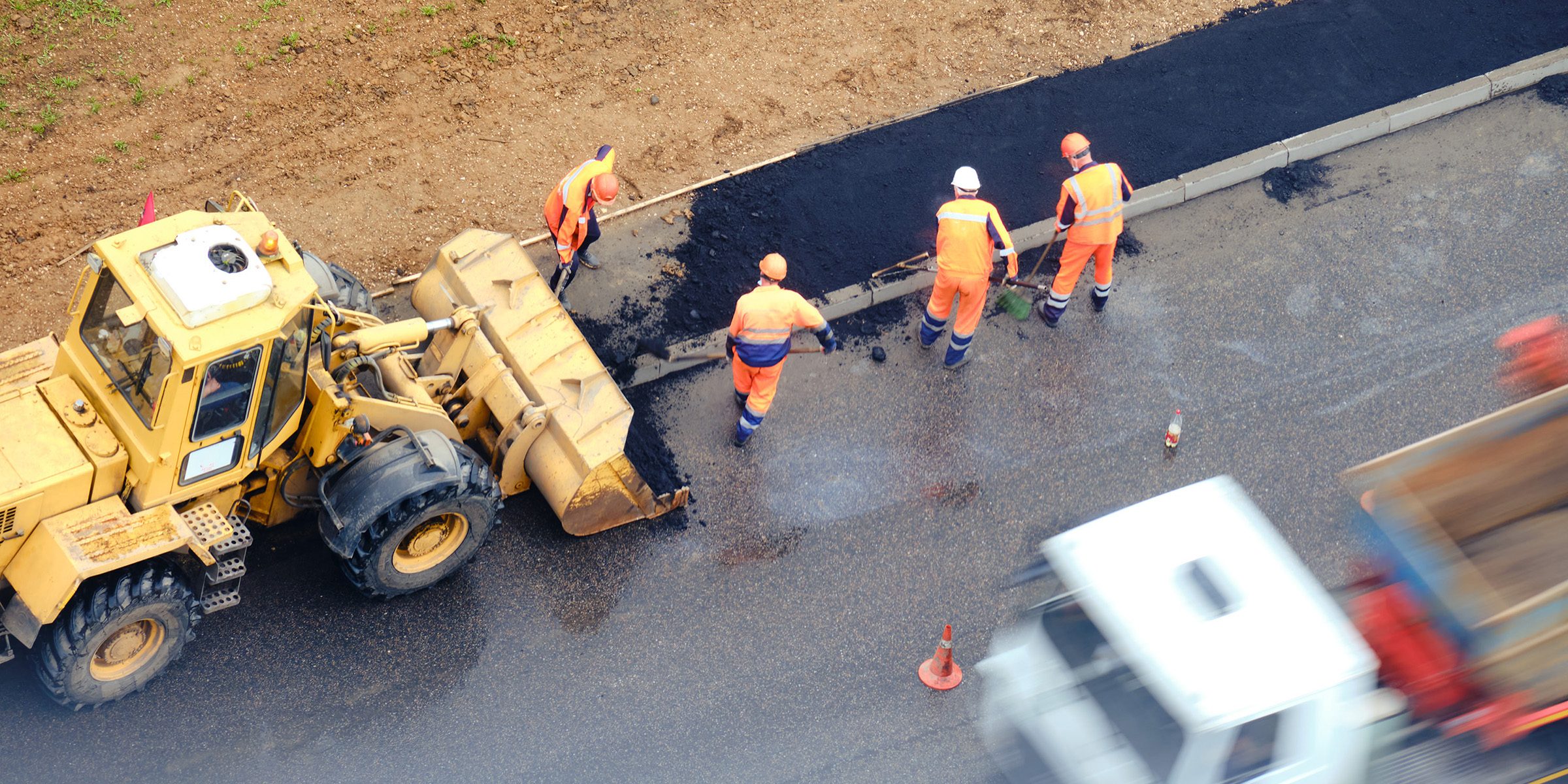Road workers laying asphalt